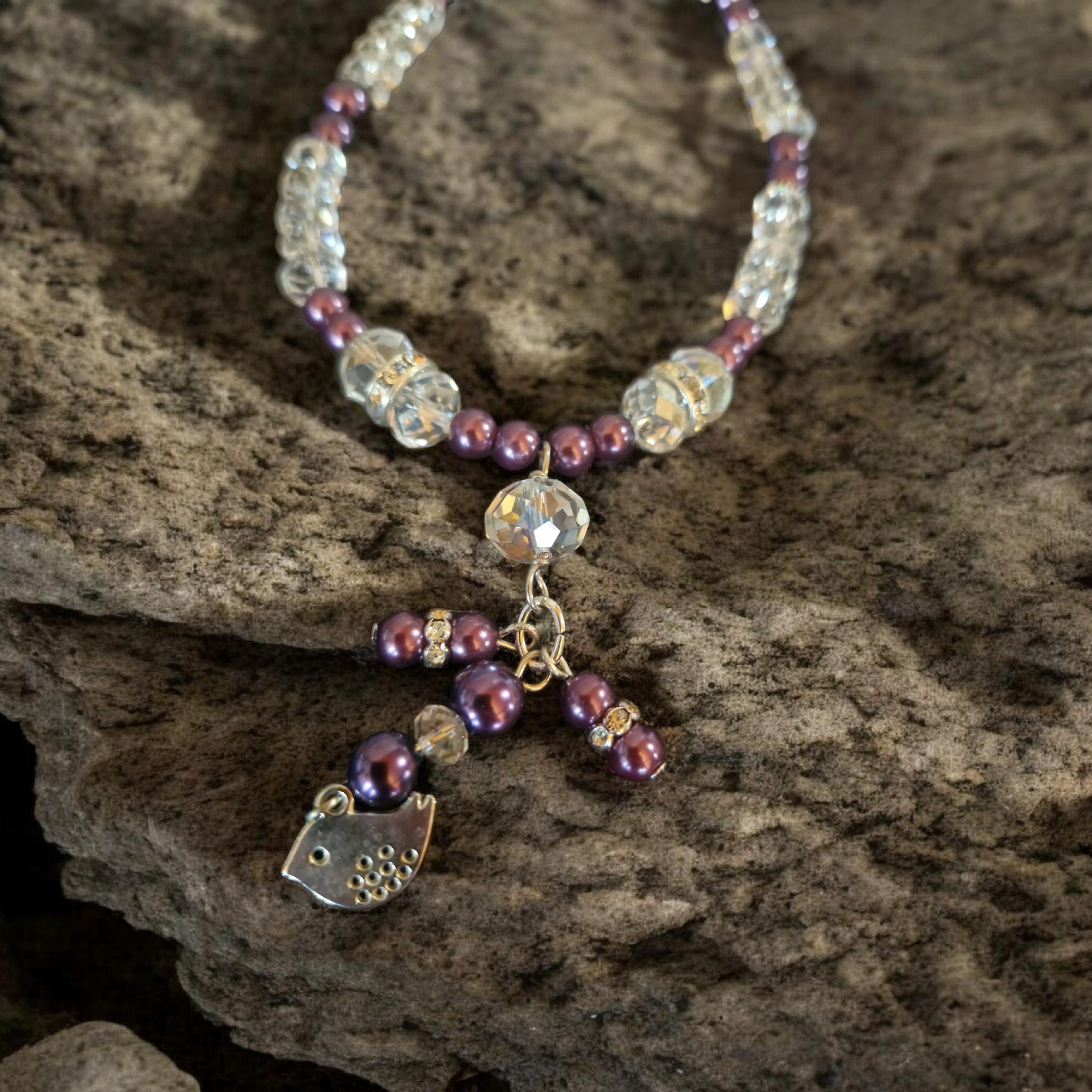 Purple glass pearls and faceted glass crystal necklace with silver bird cluster feature